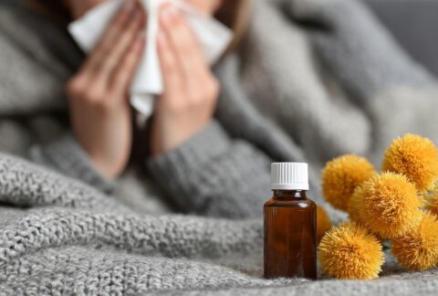 Illóolaj megfázás ellen, háttérben náthás nő zsebkendővel